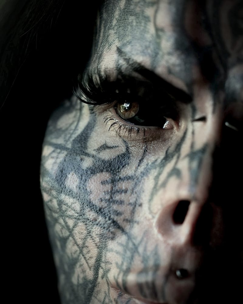Close-up of my eye with the white tattooed black, around an amber iris