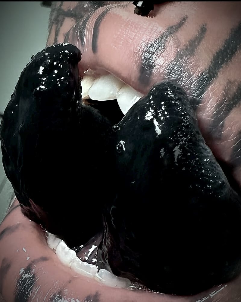 My split tongue, healed and tattooed black, the two halves apart